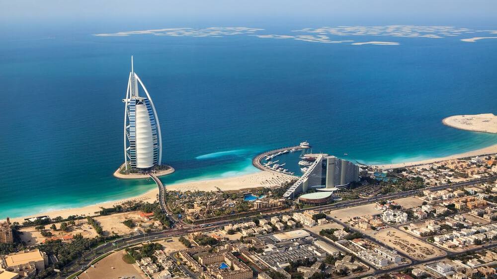 Aerial view of Jumeirah: the beach, the Burj Al Arab on the water and low-rise neighbourhoods inland